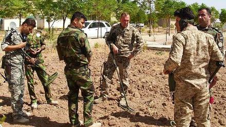 Ein Bundeswehrsoldat erklärt den Einsatz von Metallsuchgeräten.