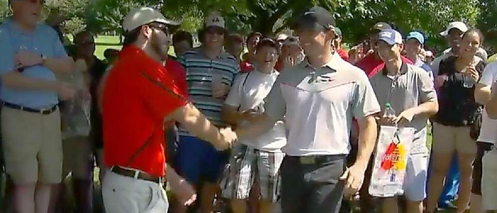 Erst ein Handshake, dann ein neuer Ball: Rory McIlroy und der Zuschauer, in dessen Hosentasche McIlroys Abschlag landete.