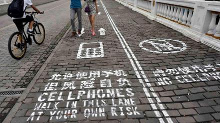Handybürgersteig in Chongqing: Auf eigene Gefahr. 