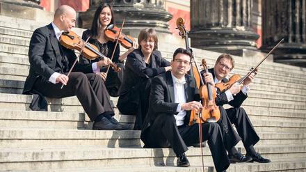 Einige Mitglieder des Kammerorchesters mit Konzerstmeister Gabriel Adorján (2. v.r.), auf der Freitreppe des Konzerthauses am Gendarmenmarkt.
