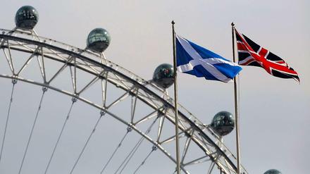 Friedlich vereint. Die schottische Flagge und der Union Jack wehen nebeneinander vor dem Riesenrad "London Eye" in der britischen Hauptstadt.