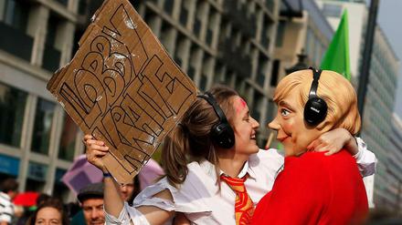 Eine Merkel-Puppe lässt sich von einer Lobbyistin küssen. Bei der Klimademonstration in Berlin am Sonntag haben rund 10 000 Menschen eine bessere Klimapolitik verlangt. Sie zogen in drei Demonstrationszügen zum Brandenburger Tor. 