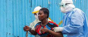 Eine an Ebola erkrankte Frau in Liberia wird von Klinikmitarbeitern in Monrovia betreut.
