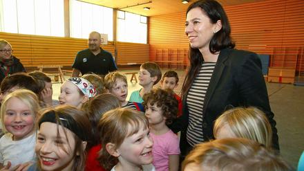 Senatorin Scheeres steht mit Schülern in einer Turnhalle.