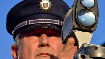Ein Polizist in Erfurt misst im Rahmen des bundesweiten Blitzmarathons am Donnerstagmorgen das Tempo von Autofahrern.