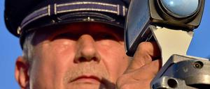 Ein Polizist in Erfurt misst im Rahmen des bundesweiten Blitzmarathons am Donnerstagmorgen das Tempo von Autofahrern.