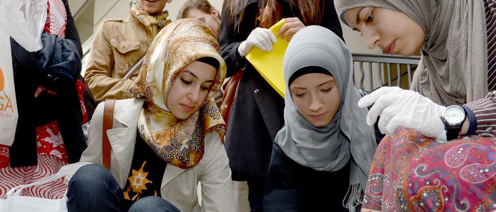 Junge Muslimas putzen Stolpersteine in Berlin. Symbolbild von 2014