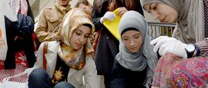 Junge Muslimas putzen Stolpersteine in Berlin. Symbolbild von 2014