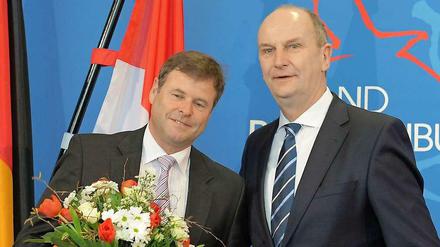 Blumen für den Partner. Ob der Strauß für die Linke auch so üppig wie bei der Ernennung Christian Görkes (l.) zum Minister?