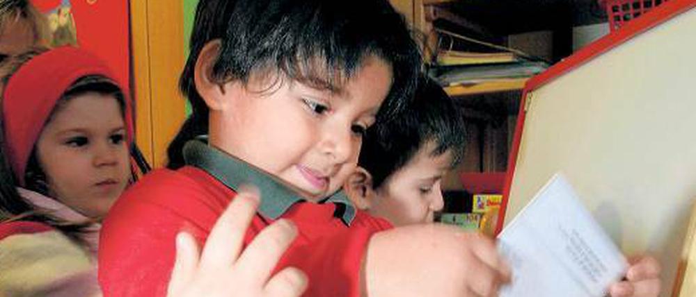Aus dem Koffer. Materialien wie der Sprachförderkoffer unterstützen die Erzieherinnen dabei, ihre Kinder besser auf die Schule vorzubereiten. Hier sieht man Kinder aus der Kita Bissingzeile in Tiergarten.