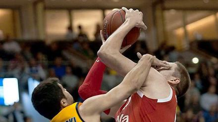 Vojdan Stojanovski (l) von Alba Berlin drückt Vladimir Stimac vom Bayern München die Finger ins Gesicht.