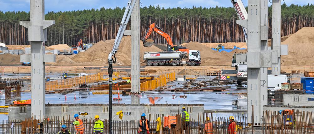 26.08.2021, Brandenburg, Grünheide: Viel Betrieb herrscht am Rohbau für die künftige Batteriefabrik auf dem Baugelände der Tesla-Autofabrik.