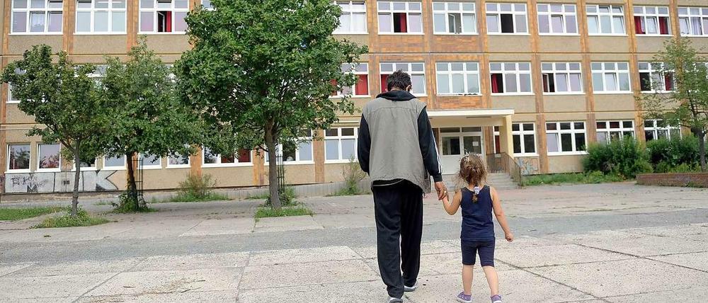 Vater und Tochter vor dem Flüchtlingsheim in Berlin-Hellersdorf. Weil der Platz in den Unterkünften knapp wird, sollen zusätzlich Container aufgestellt werden.