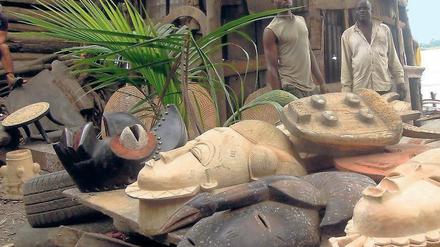 Arbeitsfluss. Am Hafen von Abidjan werden Masken und Statuen hergestellt, aus dem Abfallholz des Exports. 