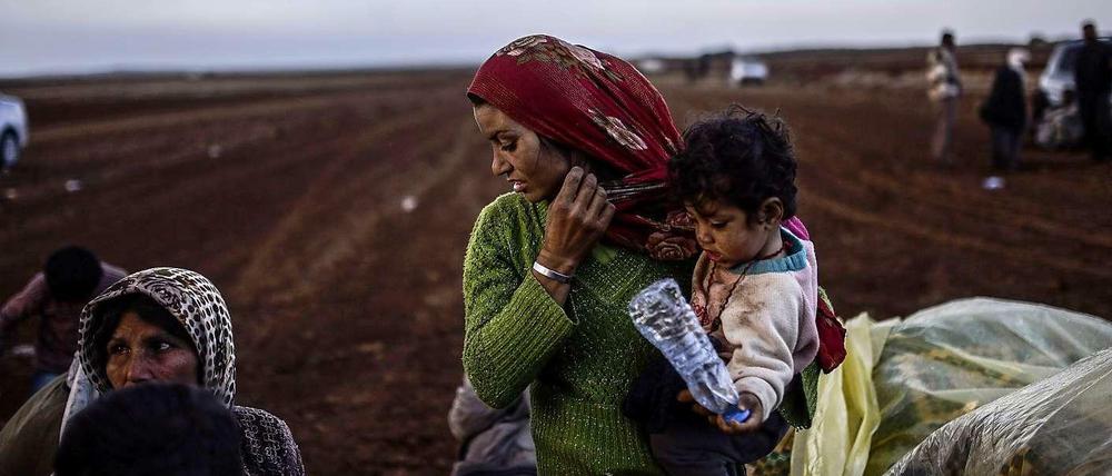 Syrische Kurden warten an der Grenze zur Türkei nahe der Stadt Suruc darauf, die Grenze überschreiten zu dürfen. Sie sind vor Kämpfen und dem Islamischen Staat geflohen. Hunderttausende Menschen sind auf der Flucht vor den selbst ernannten Gotteskriegern. 