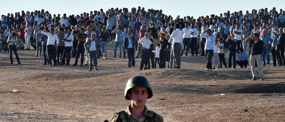 Kurds are gathering oppisite the syrian city of Kobane or Ain al Arab. The city is surrounded by the "Islamic State" and the people of the turkish side fear a massacre. 