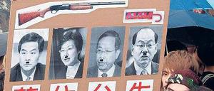 Verunglimpft. Demonstranten zeigen Männer mit Schnurrbärten, die an Adolf Hitler erinnern sollen. Unter ihnen ist Hongkongs Regierungschef Leung Chun Ying.