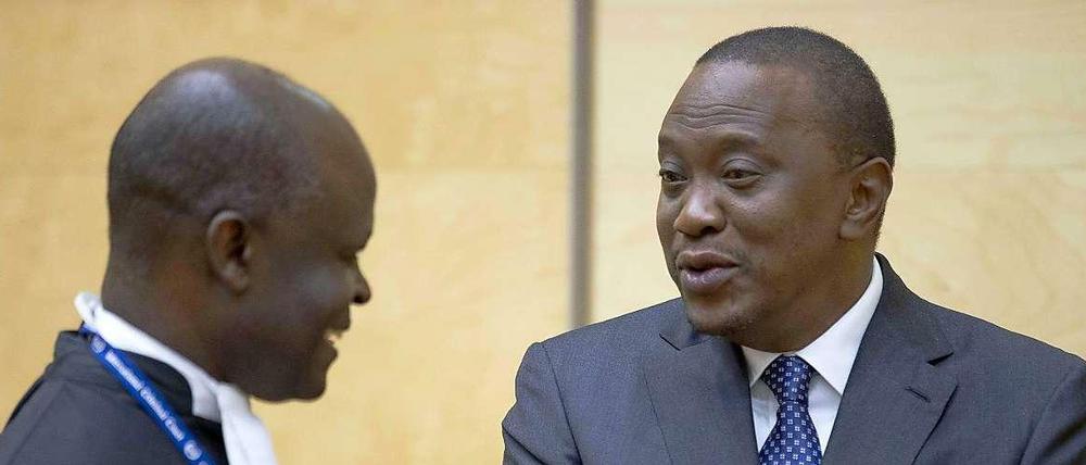 Besonders ernst nimmt der kenianische Präsident Uhuru Kenyatta den Internationalen Strafgerichtshof in Den Haag nicht. Dennoch ist er vor Gericht erschienen. Denn einen internationalen Haftbefehl wollte er sich dann doch nicht einhandeln. Das Foto zeigt ihn mit einem seiner Anwälte im Gerichtssaal. 