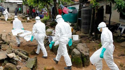 Krankenschwestern in Liberia tragen ein Ebola-Opfer.