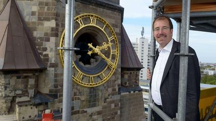 Wanderbaustelle. Martin Germer, Pfarrer der Kaiser-Wilhelm-Gedächtniskirche, auf dem Gerüst am neueren Glockenturm neben dem sanierten Altbau.