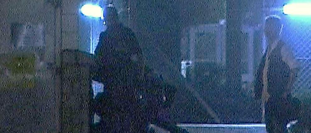 Dieses Foto zeigt, wie der Demonstrant im Dunkeln von Polizisten misshandelt wird.