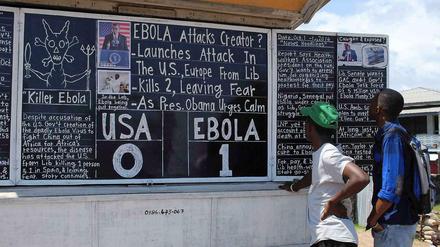1:0 für Ebola: In Monrovia informieren sich die Leute an einer Nachrichtentafel.