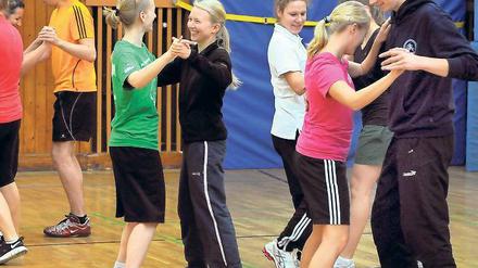 Studierende beim einem Tanzkurs in einer Sporthalle.