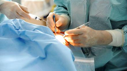 Ein Operateur arbeitet mit chirurgischen Instrumenten an einem Patienten.
