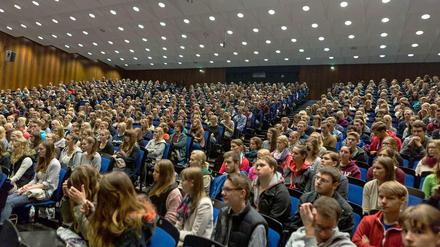 Studienanfänger sitzen in einem vollen Hörsaal.