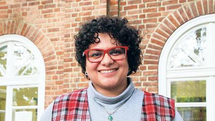 Leila Papoli Yazdi steht lächelnd auf der Terrasse eines Hauses.