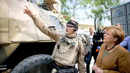 Am frühen Freitagmorgen brach Kanzlerin Angela Merkel zu einem Besuch nach Afghanistan auf. Hier besucht sie gerade ein Feldlager in Kundus. 