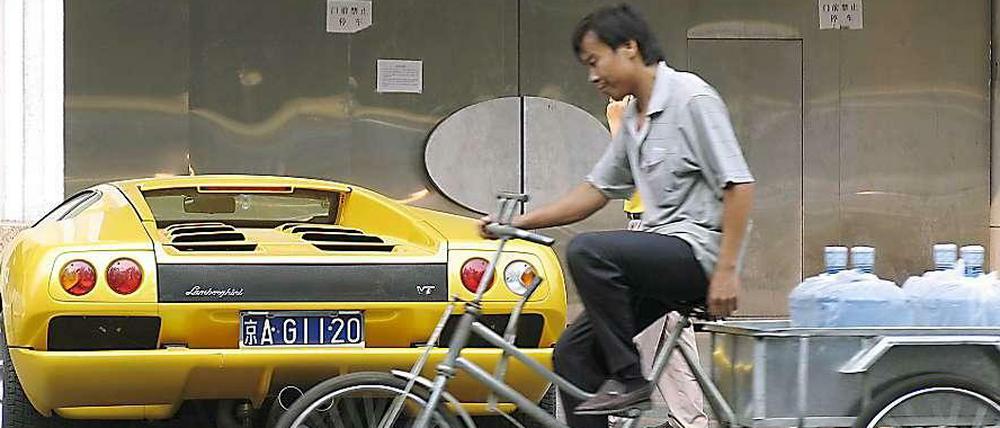 Fahrrad und Luxuskarosse - in China sind die sozialen Unterschiede groß. 