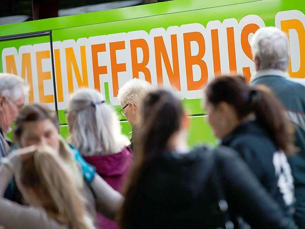 Reisende stehen vor einem Fernreisebus