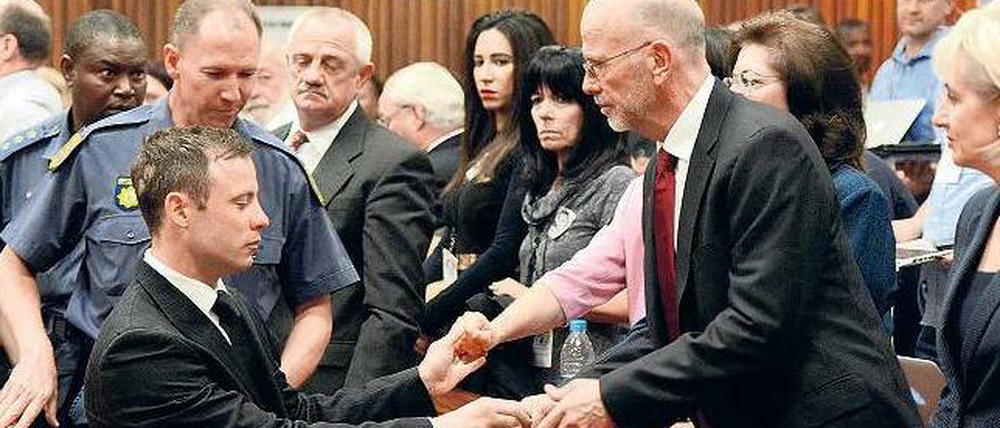 Abgeführt. Oscar Pistorius gibt noch seiner Familie die Hand, bevor er in die Zelle muss.