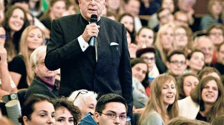 Hamburgs Unipräsident steht im Hörsaal unter Studierenden.
