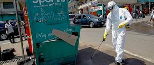 Ein liberianischer Helfer desinfiziert eine Straßenecke, an der ein mit Ebola Infizierter aufgegriffen wurde. 