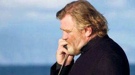 Dorfpriester Lavelle (Brendan Gleeson) nimmt die Beichte schon mal fernmündlich ab. 