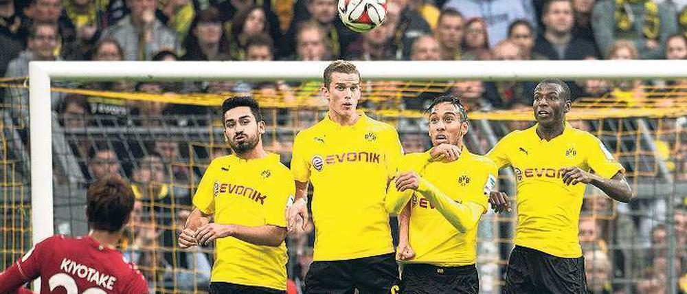 Die Borussia bröckelt. Hannovers Hiroshi Kiyotake zirkelt den Ball zum 1:0 über die Mauer des BVB. Ilkay Gündogan, Sven Bender, Pierre-Emerick Aubameyang und Adrian Ramos (von links nach rechts) springen vergeblich in die Luft.