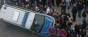 In Köln warfen die Demonstranten einen Polizeiwagen um.