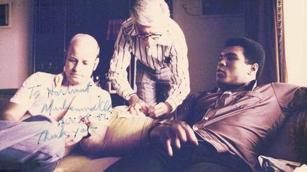 „To Hartmut.“ Unser Autor Hartmut Scherzer (links) sitzt mit Muhammad Ali in dessen Bungalow in Kinshasa. Dick Young von der „New York Post“ (M.) ist auch dabei. Später schrieb Ali eine Widmung auf das Foto.