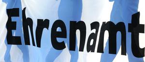 Jugendliche halten in Freiburg vor einem Fußball-Bundesligaspiel ein Banner mit der Aufschrift "Ehrenamt" in den Händen.