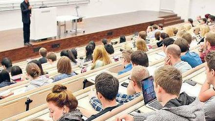 Ein Dozent steht im Hörsaal vor Studierenden.