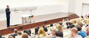 Ein Dozent steht im Hörsaal vor Studierenden.