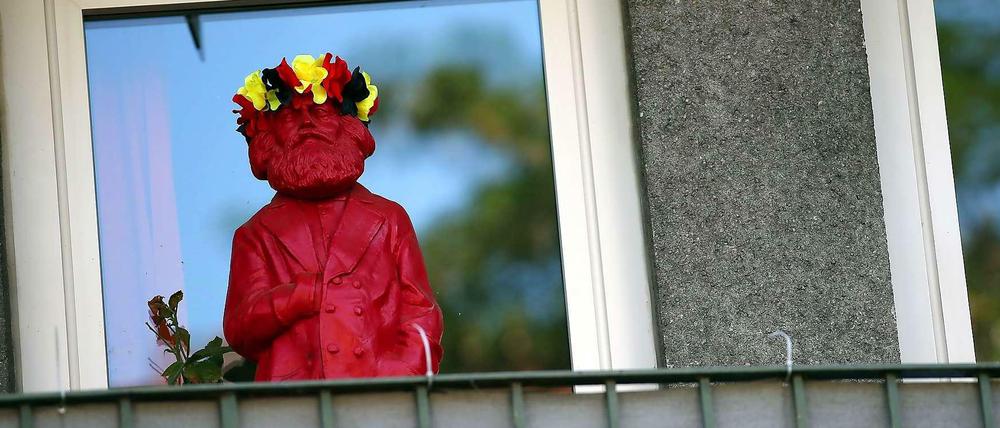 Drollig und draußen. Hier freut sich ein Bewohner mithilfe einer dekorierten Karl-Marx-Figur offensichtlich über Erfolge der deutschen Fußballnationalelf. Fröhliches Singen auf dem Balkon ist in Berlin jetzt vom Ordnungsamt in Friedrichshain untersagt worden.