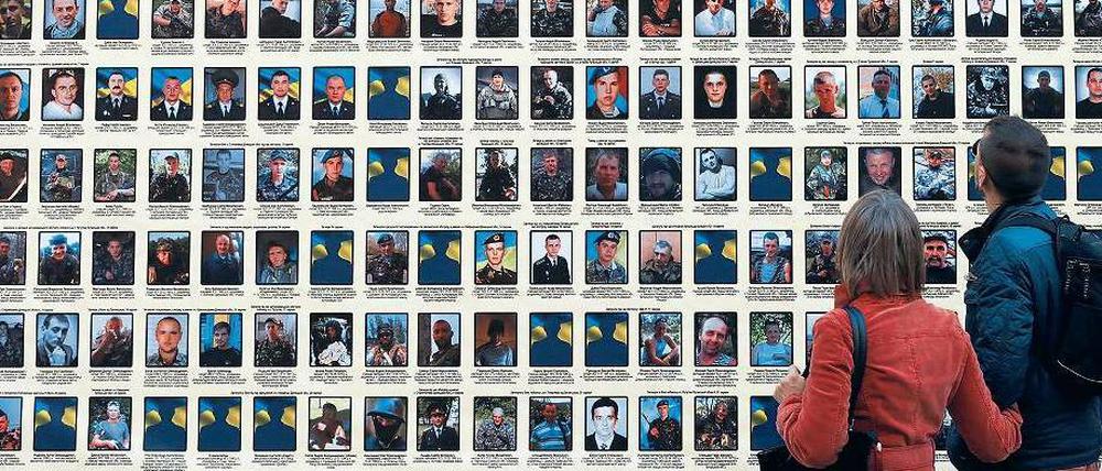 Trauer. Passanten betrachten in Kiew Porträts von Soldaten, die im Kampf gegen die Separatisten gefallen sind.