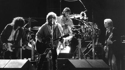 Der amerikanische Rockpoet Bob Dylan (M) und der US-Rockmusiker und Gitarrist Tom Petty (r) mit seiner Band "Heartbreakers" begeistern am 17. September 1987 die Zuschauer beim Friedenskonzert des DDR-Jugendverbandes "Freie Deutsche Jugend" (FDJ) auf der Treptower Festwiese in Berlin mit ihren Songs.