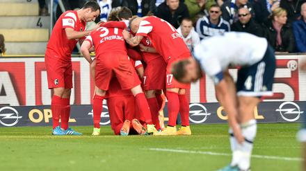 Freud und Leid: Der SC Freiburg jubelt, Schalkes Benedikt Höwedes (vorn) ist ratlos.