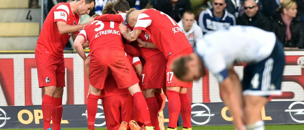 Freud und Leid: Der SC Freiburg jubelt, Schalkes Benedikt Höwedes (vorn) ist ratlos.