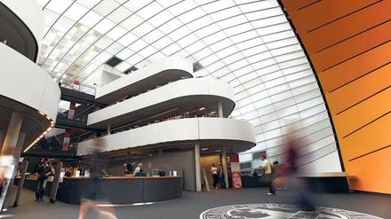 Menschen gehen durch das Foyer einer Bibliothek.