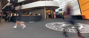 Menschen gehen durch das Foyer einer Bibliothek.